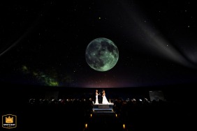 A couple exchanging vows under a moonlit sky inside the Franklin Institute Planetarium in Philadelphia, PA.